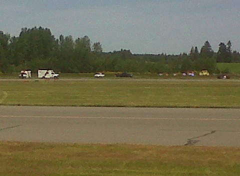 Ambulances wait on runway while emergency crews tend to crash scene in background (looking east from flying club)